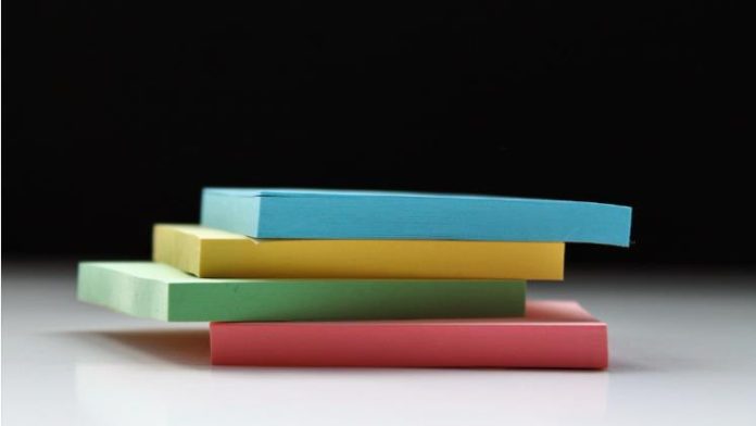 Four packs of different-colored sticky notes stacked on top of each other representing the stacked nature of a stacked chart.